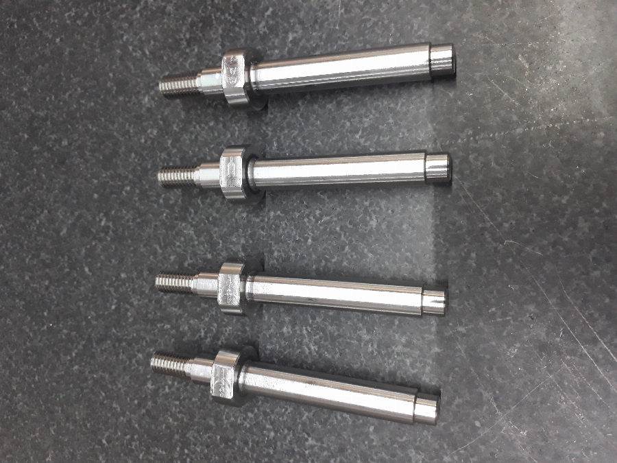 Imagen detallada de un componente de aluminio maquinado con precisión, mostrando las tolerancias dimensionales críticas en un orificio y un eje.